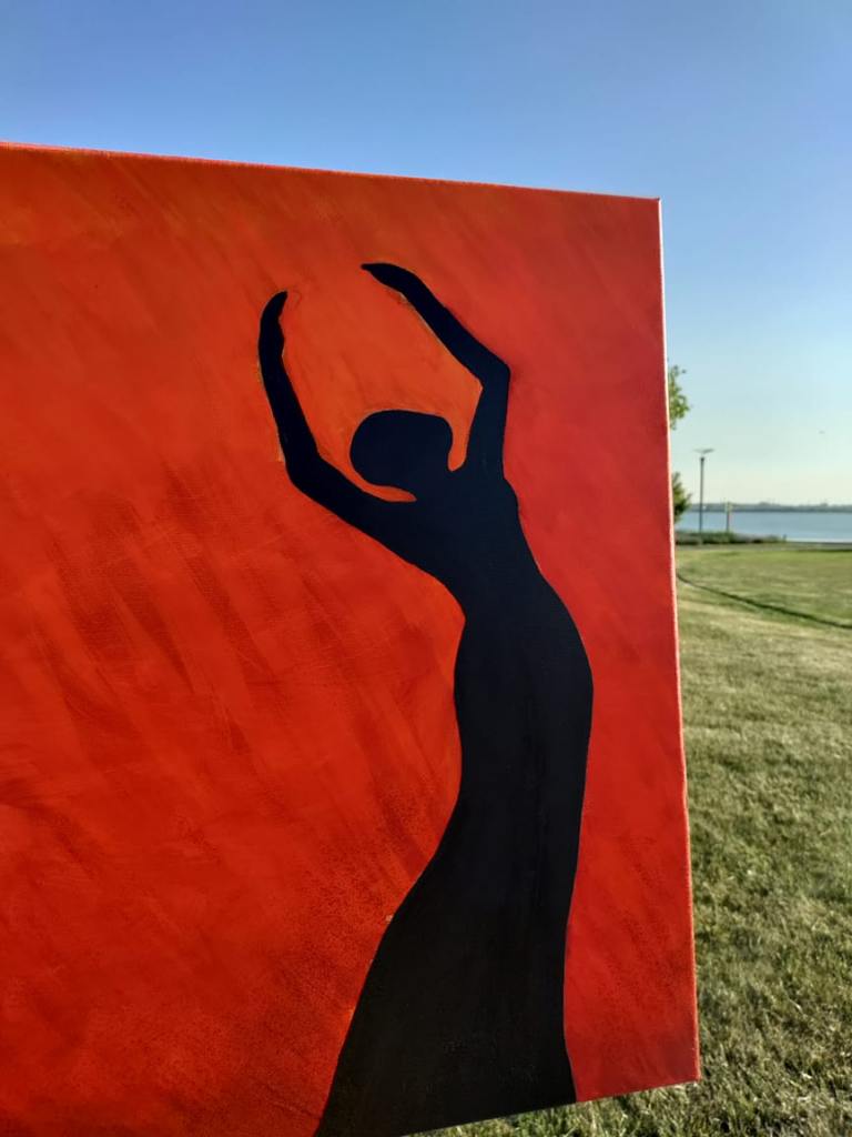 Pictured: A painting. Red orange flames cover canvas background. All black silhouette of a praise dancer with arms fully extend in worship, back arched. Caption: My newest painting in my Sunsets & Silhouettes Collection. Fire Dancer, by Marlene Dillon Copyright 2021.